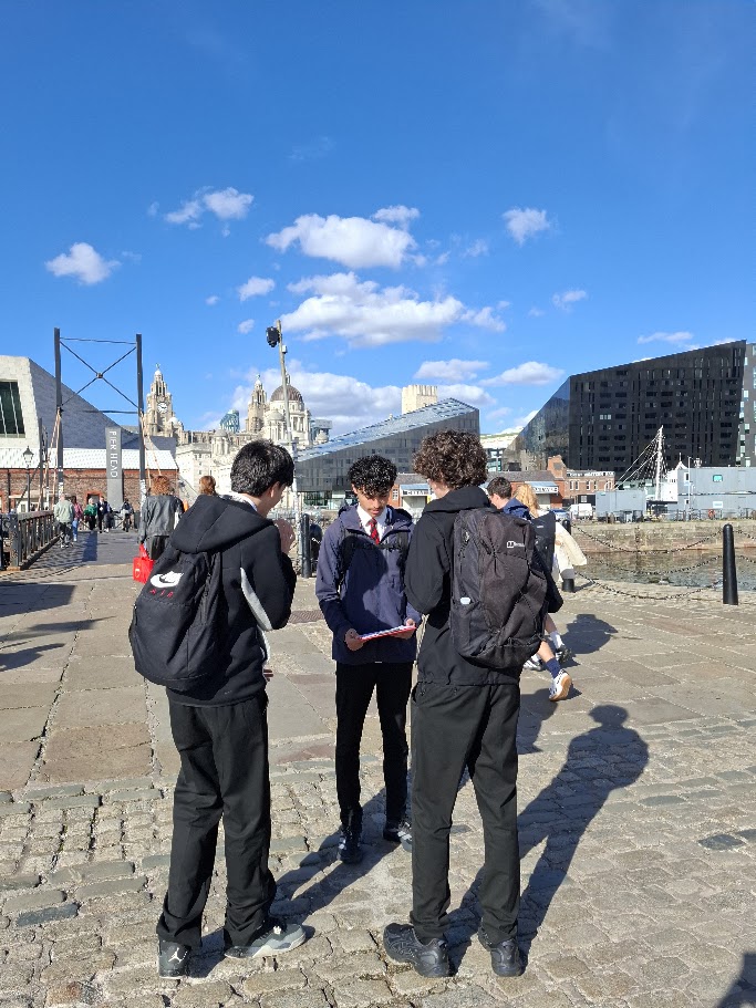 Three students stood at the Albert Dock during their geography field work trip